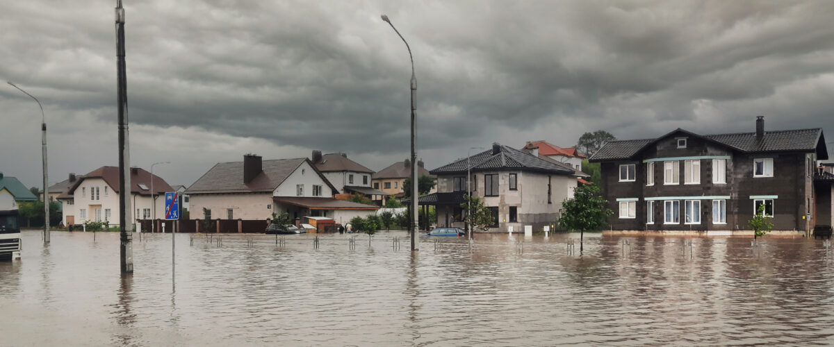 Bad extreme heavy rain storm weather. Flooded streets of the neighborhood. A flooded road junction with a drowned car. Heavy rains from tropical storm caused many flooded areas.
