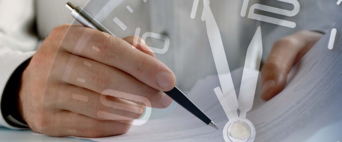 Businessman working to a deadline on paperwork in a conceptual image overlaid over the dial of a clock showing five to twelve