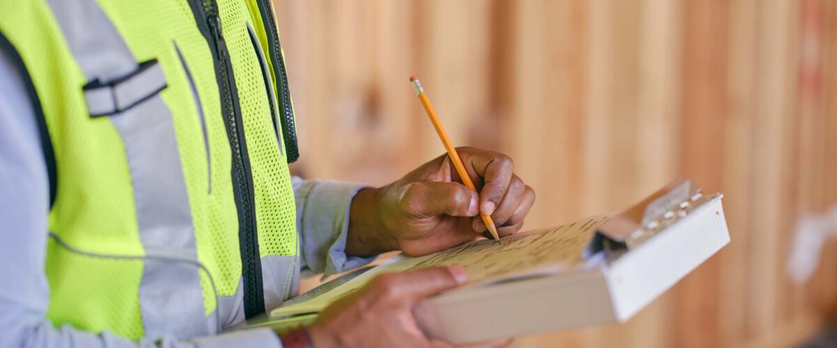 A construction worker inspecting a home under construction.